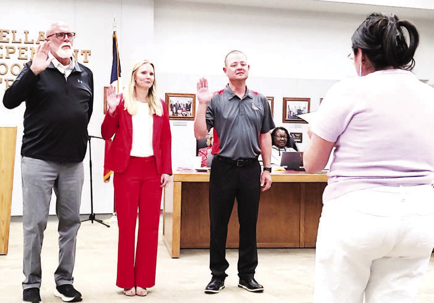 LISD SWEARING IN-- LISD administrative secretary Crystal Hill swore in the board members elected to serve at the recent meeting: Gary Bridges, Carrie Ellis and Matt Buxkemper. (Staff photo)