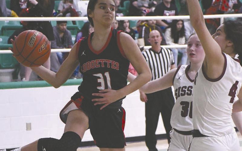 LOOKING FOR HELP- The sixth ranked Levelland Loboettes eliminated the Bridgeport Sisses, 44-18, in Hamlin Friday evening to become the 4A Region 1 Area Champions. Loboette Leilani Sanchez looked for an open teammate as she left her feet to make a pass. (Staff Photo by Dom Puente)