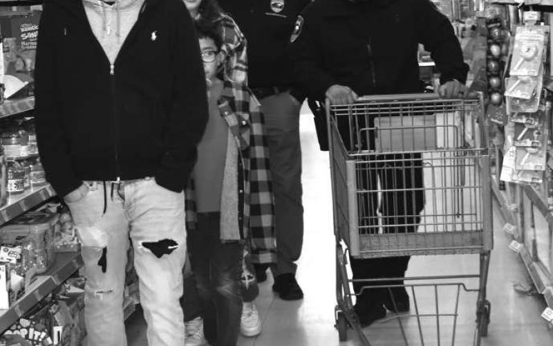 TIME TO SHOP - Blue Santas were helping the children shop at Walmart during the third annual Blue Santa Event last Saturday. The Levelland Police Department where able to host 29 children and help them with there gifts they chose. (Staff photo By Emily Campos)