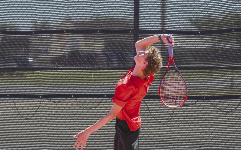 STRONG SERVE - Varsity Lobo Tennis player Ryeton McMahan made several strong serves during his doubles match against Seminole on Tuesday. (Staff photo by Dom Puente)