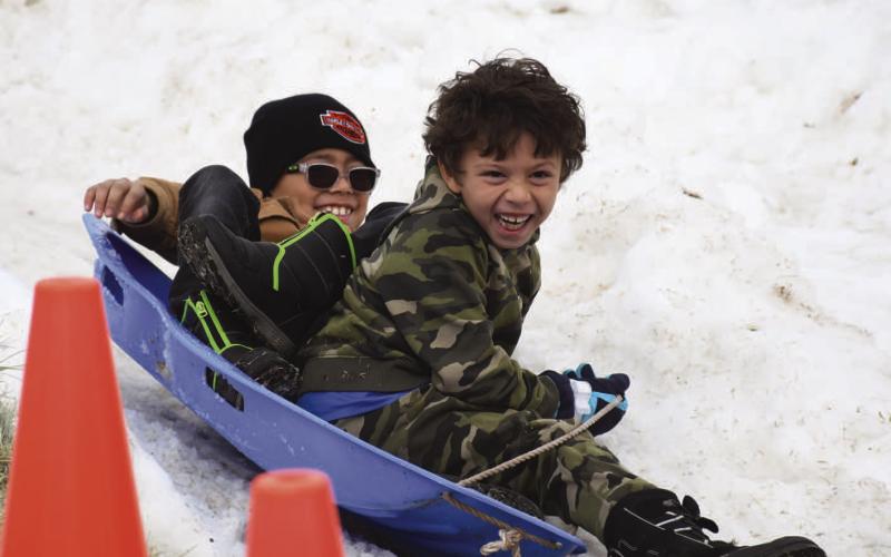 WINTER SMILES - Kids of all ages were able to play at the Lobo Lake Sled Hill during the final week of 2022. Due to warmer temperatures, the sled hill was able to operate for three days out of the week. Kids continued to fill the sled paths throughout the week to round out the year. (Staff Photo)
