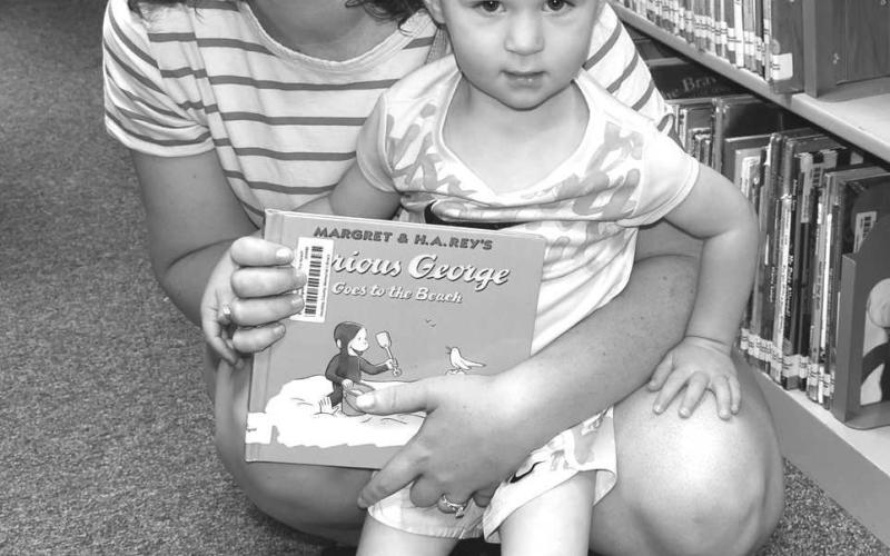 LIBRARY BOOK- Many children participated in the Library Summer Program on Wednesday. They had an opportunity to read and check out library books.Pictured are Penny Bayer and Mikkadee Bayer. (Staff photo by Emily Campos)