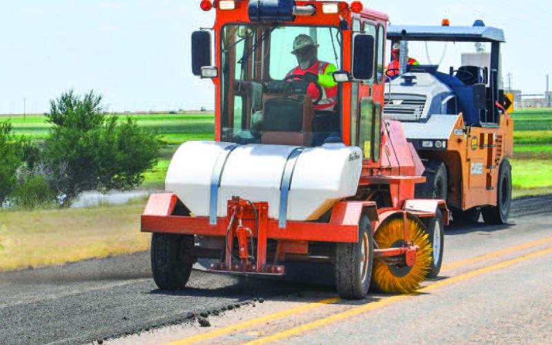 ROAD WORK - Hockley County TxDOT crews have been busy this past week as they have been working on county roads west of Levelland. Pictured are crews working on N. FM 2646, laying new asphalt along side the edges of the road. (Staff photo by Emily Campos)