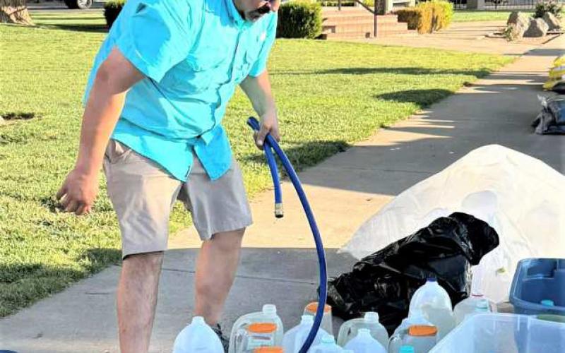 FILLING WATER JUGS- Community members worked this past Saturday, cleaning up and repotting plants around the Hockley County courthouse lawn. (City of Levelland Main Street photo)