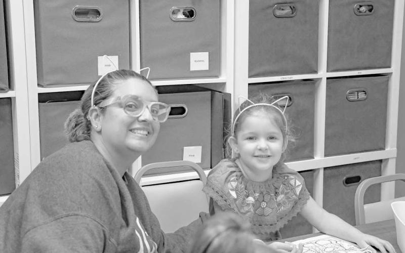 KITTY EARS - Pictured from left to right are: Rebekah Chavez and Frida Mcgowan who had a blast coloring and eating apples during Art and Apples at the Hockley County Memorial Library on Wednesday. (Staff photo by Hannah Woodrum)