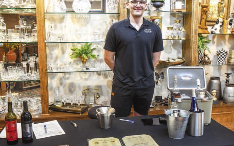 Stefan Ardeloff with English Newsroom smiled after serving guests wine in Atchinson’s Jewelry during Friday night’s Sip and Swirl event. (Staff photo by Evin Thomas)