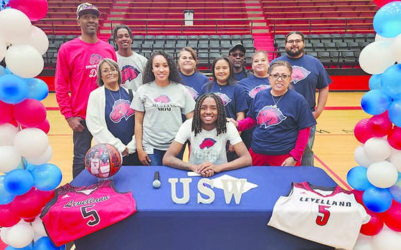 HEADED TO SOUTHWESTERN- Levelland Lobo Taeshaun Jones signed to Southwestern University Thursday morning at Levelland High School. Front row is Taeshaun Jones; middle row L-R are: Mary Quevedo (great grandma), Erica Jones (mom), Rochelle Sigua (aunt) and Tommie Vidales (aunt); back row L-R are: Ashanti Jones (dad), Eryk Jones (brother), Anita Ovalle (grandma), Tony Manahan (grandpa), Misty Combs (step grandma) and Steven Manahan (uncle). (Staff Photo by Dom Puente)
