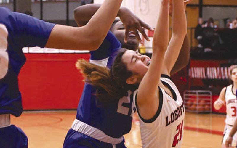 HARD FOUL- In a nail-bitter of a matchup against the Estacado Lady Matadors, the Levelland Loboette basketball team secured their third straight district championship, 57-51, in overtime. Loboette Carly Tienda was fouled hard on a lay-up attempt. (Staff Photo by Dom Puente)