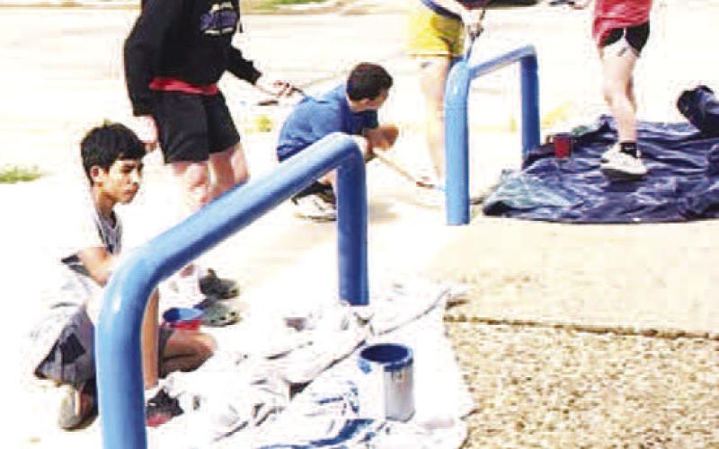 COMMUNITY PROJECT - Sundown XC runners took the morning off from workouts for a community project to repaint the hand railings and parking stops at City Hall as well as the water refill station. (Sundown ISD photo)