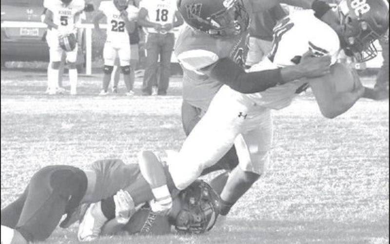 GROUP TACKLE - Stifling defense was the name of the game in a 50-0 Whitharral Panther win over the visiting Kress Kangaroos last Friday in UIL class 1A six-man football action. Here Nate Sansom and Brolin Kennedy combine to bring a Kress runner down. The Panthers will host Silverton next Friday at 7 p.m. Last season, the owls stunned the heavily favored Panthers 34-30 in Silverton. The Owls are currently 2-0, coming off wins over Petersburg (74-61) and Paducah (64-46). (Staff photo by Jay Kelley)