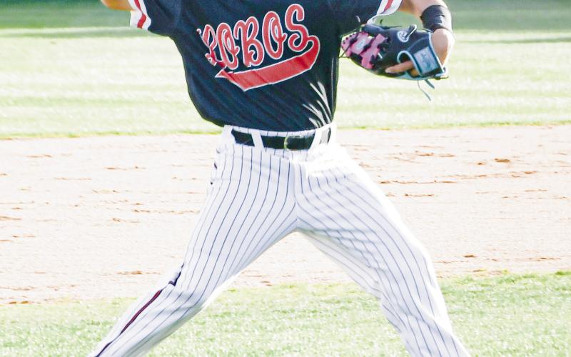 THROW ‘EM OUT - Levelland Lobo Braylon Delcampo fields the baseball in the infield grass and makes a throw to record an out during their district baseball game against Liberty this past Friday night at Levelland High School. (Staff photo by Jentezen Smith)