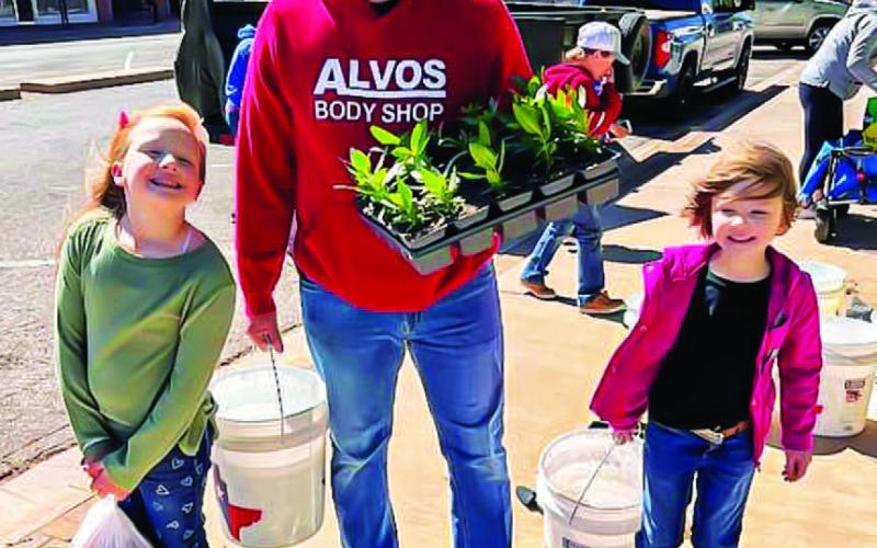 FAMILY FUN - Community Planting Day at the downtown square Saturday morning was a success for the volunteers as they spent the morning taking care of and setting plants. Pictured is the Tucker family with Jacob planting with the help of his daughters Lilly and Charlie Pearl. (Photo courtesy of Andrea Corley)