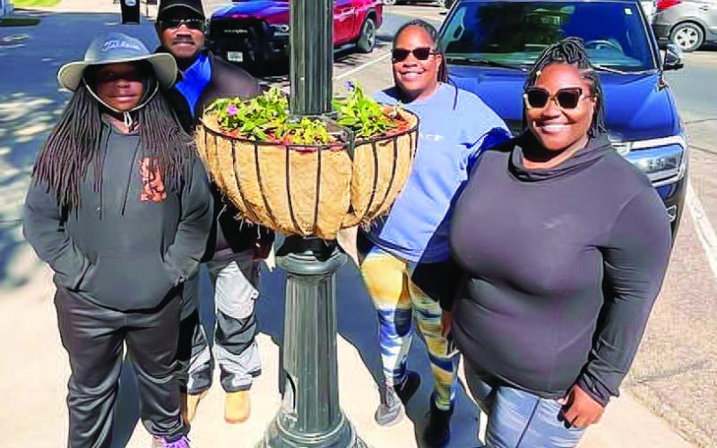 MORNING PLANTING - Community Planting Day participants were able to dedicate the planters to people and organizations. Planters were dedicated to veterans, parents, grandparents and family members. Even though there are people responsible for watering the plants, people visiting downtown are encouraged to take a few minutes to water a planter. The community is heavily encouraged to water the plants, but to be careful about over watering since it can kill plants. (Photo courtesy of Andrea Corley)