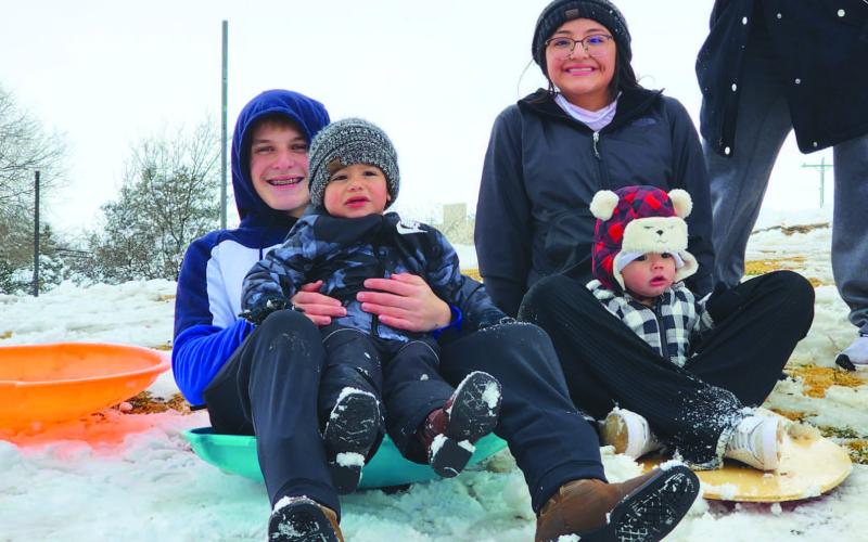 WINTER WONDERLAND - With nearly four inches of snowfall for the city of Levelland after Monday nights winter storm, community members took advantage of playing in the snow Tuesday as classes were canceled. Pictured on the left is Brent Billington holding Nolan Estrada and Hailee Estrada holding Easton Estrada as they slid down Lobo Hill. (Staff Photo)