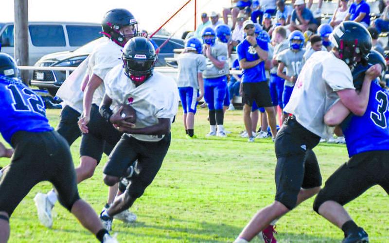 HIT THE HOLE – Whitharral senior running back Brent Robinson takes the handoff from senior quarterback Damian Rodriguez and hits the running lane during a scrimmage last Friday at home against the Lubbock Titans and Nazareth. (Staff photo by Jentezen Smith)