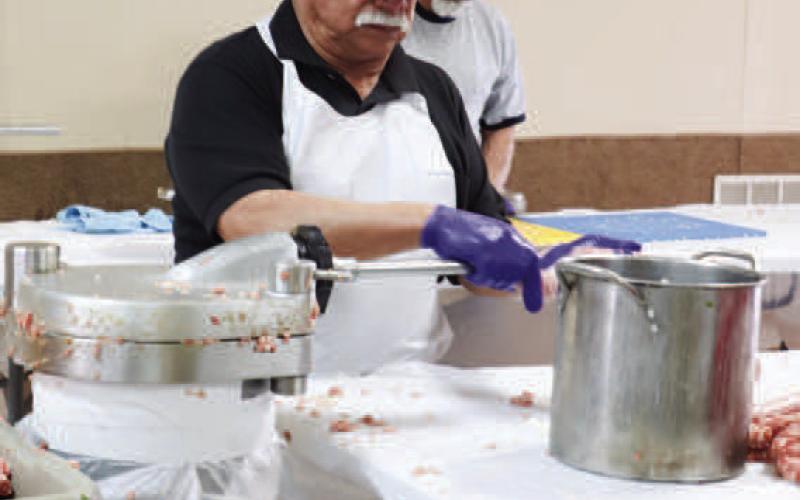 LONGSTANDINGTRADITION - Pictured is Albert Castillo Jr. helping tube the sausage Friday at St. Michael’s Catholic Church. The 40th Annaul Sausage Lovers Festival will be held Sunday, Feb. 16. (Staff photo by Adriana Solis)