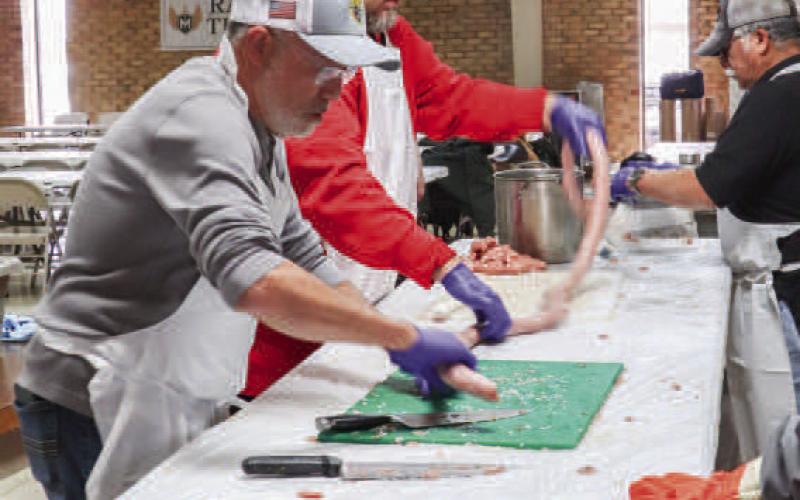 TEAMWORK - Gilbert Salazar and Nicholas Denzel worked together to tube the sausage Friday at St. Michael’s Catholic Church. The 40th Annaul Sausage Lovers Festival will be held Sunday, Feb. 16. (Staff photo by Adriana Solis)