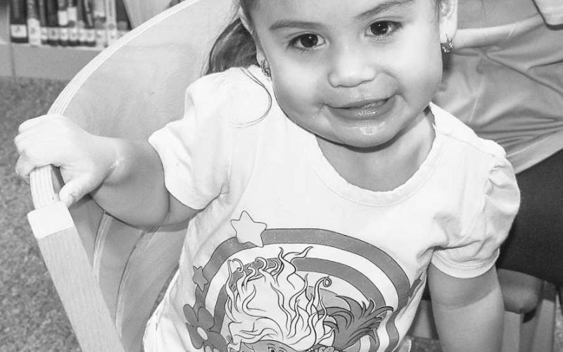 TIME AT THE LIBRARY - Rosalyn Torres is starting her love for reading young by participating in the Hockley County Library Summer Program this past Wednesday. Torres spent time with her sister, uncle and aunt at the library. (Photo courtesy of Emily Campos)