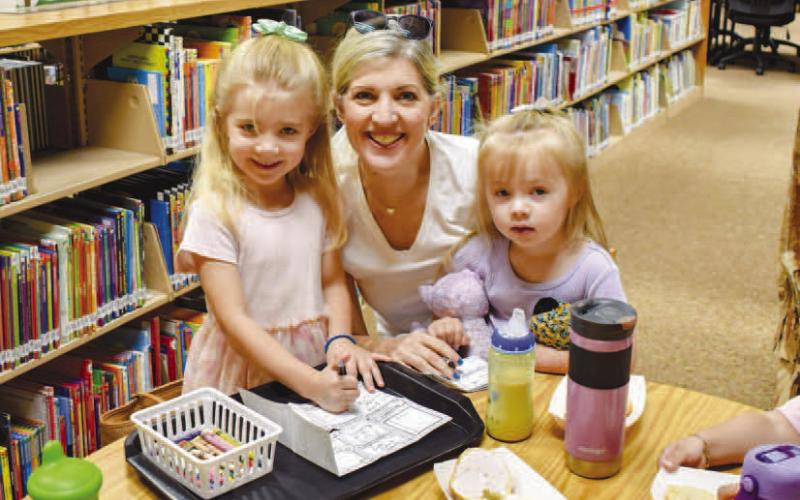 FAMILY FUN DRAWING- Pictured is Sharon Rice and grandaughters Racheal and Emma Rice who participated in the Hockley County Library Summer Program on Wedesday. The three enjoyed eating bagels and drawing what they wanted to be. Emma’s drawing showed that she wants to be a princess and Racheal’s drawing showed that she wants to be a Queen. (Photo courtesy of Emily Campos)