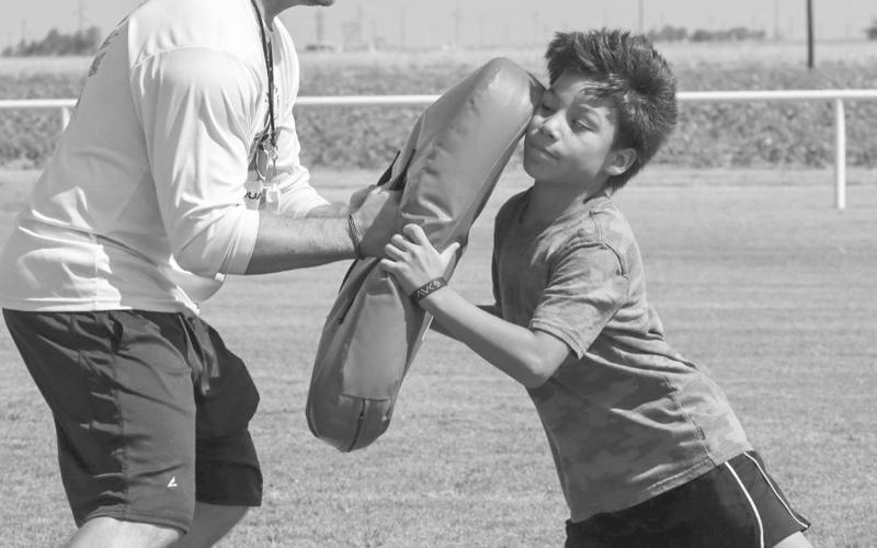 BLOCKING - Head Football Coach Jeremy Holt taught Panther Thiago Rendon hand placement for blocking on the pads this past Monday at the Whitharral Football Field. (Staff photo by Aalijah Soliz)