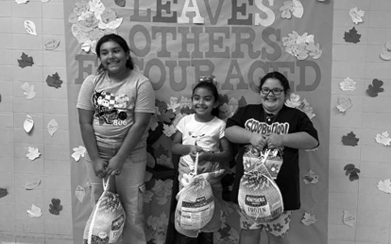CAPITOL ELEMENTARY TURKEY TROT--The Capitol Elementary Parent Club recently held a Turkey Trot for Capitol students during their P.E. classes. Families could pay $1 to buy raffle tickets for a chance to win a free turkey for one student per grade level. All proceeds went to the Capitol Elementary Parent Club. Pictured from left to right: 4th grade winner Annalise Sanchez, 2nd grade winner Elsy Huerta, and 3rd grade winner Serenity Butler (photo courtesy of Capital Elementary)