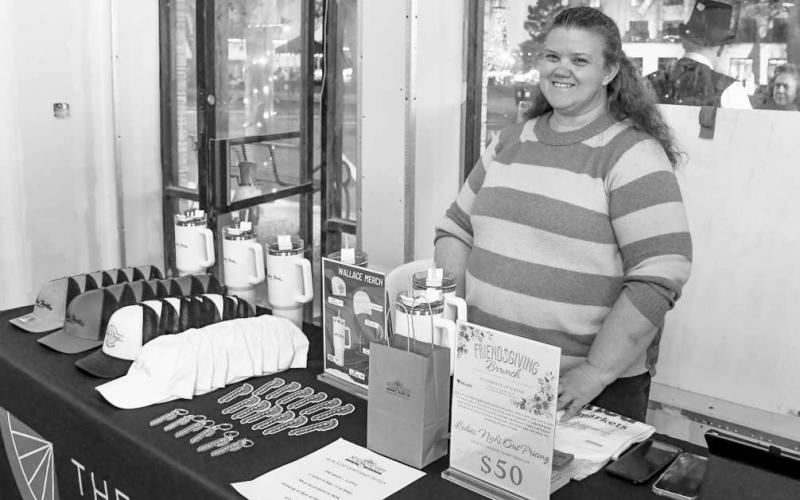 WALLACE STANDS – Tina Wiiest smiled at a Wallace Theater merchandise stand set up for attendees of Ladies Night Out in downtown Levelland on Thursday night. (Staff photo by Evin Thomas)