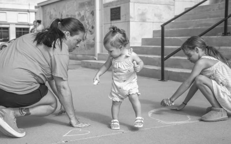 CHALKING IT UP – Hadlee and Aubree Huckabee got down and dirty with chalk on Wednesday at the Hockley County Memorial Library’s Fun with Chalk event. This even allowed kids and adults to express their creativity on the sidewalks outside of the library. (Staff photo by Hannah Woodrum