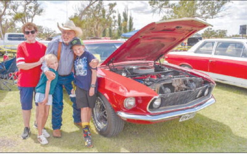 FUN WITH FAMILY – Pictured is Dan Patterson with his wife Joy Patterson and his grandkids Braelynn Patterson and Marshall Conklin. Patterson attended Levelland High School and has had his 1969 Ford Mustang since then. It has been through two tornadoes, light vandalism, and four teenage drivers from the same family all while retaining its original Candy Apple Red paint. The car won second place in the 1964- 1981 Ford Muscle Car Class at the Thunder on the Plains Car Show on Saturday at the Levelland City Par