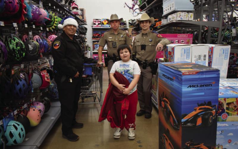 Pictured are Detective Lopez and DPS Troopers Rigdon and Wall buying Christmas gifts for local children at the Blue Santa event on Saturday at Walmart. (Staff photo by Ada Niederhauser)