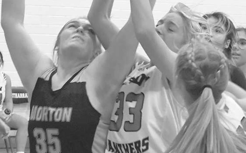 REBOUND BATTLE- Whitharral’s Avery McCain and Morton’s Kayleigh Boggs fought for a rebound last Tuesday in girls’ high school basketball action in Whitharral. The final score was 31-28 Whitharral, but the game goes down as a forfeit as Whitharral is playing a junior varsity schedule due to numbers. The Whitharral girls will be in Cotton Center on January 3. (Photo by Jay Kelley)
