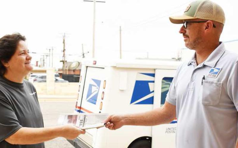 READY FOR CHANGE— Pictured are Katie Ervin and postal carrier Jeremy Ladd exchanging an issue of the Levelland &amp;amp; Hockley County News-Press. Starting Wednesday, September 10, all newspapers will be delivered to subscribers by the post office. (Staff photo by Hannah Woodrum).