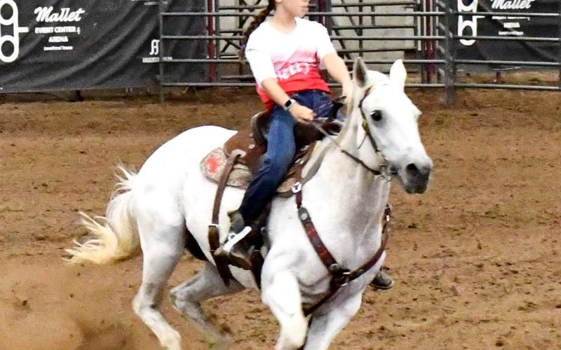 ON THE GO- Charmed by Passion is the name of Savannah Samel’s horse who competed at the Betty’s Barrel Horse Racing on Saturday at the Mallet Event Center and Arena. The duo made it look effortless as Samel’s team finished the race. Audience members gave the duo a round of applause for the solid finish. (Staff photo by Emily Campos)