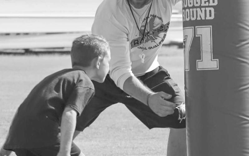 WRAP UP - Whitharral Coach Jeremy Holt and Panther Alex Fredrick worked on wrapping up for a tackle last Monday at the Whitharral Football Field. (Staff photo by Aalijah Soliz)