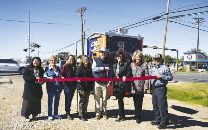 RIBBON CUTTING - A newly rewrapped bungalow can be seen at the corner of Sherman and HWY 114. Pictured left to right: Arra Delos Santos, Barbra Pinner, Angie Yandell. Adrian Mellberg, Dane Dewbre, Cristal Isaacks, Mary Siders and Freddy Ruiz. (Staff photo by Hannah Woodrum)