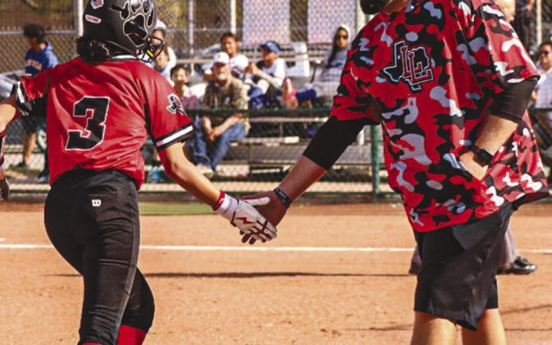 HOME RUN - Levelland Loboette Jazlyn Diaz and Head Softball Coach Ryan Miller high-fived during the team’s game against the Lake View Maidens last Friday after Diaz hit a home run. (Staff photo by Aalijah Soliz)