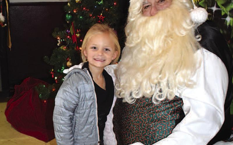 ALLIWANTFORCHRISTMAS– Laikyn Scarlet, 5, enjoyed visiting with Santa while telling him all she wanted for Christmas. She and her kindergarten classmates from Mrs. Flores and Mrs. Almanza’s class from Levelland ABC took a field trip to the Wallace Theater where they visited with Santa, participated in activities and watched a movie in the theater. (Staff Photo by DeeLaine Ruiz)