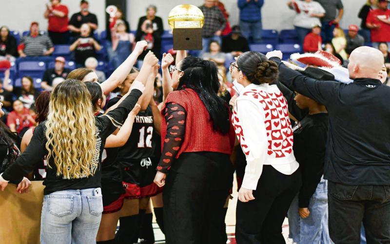 BI-DISTRICT CHAMPS BREAKOUT - The Whitharral Lady Panthers players, coaches and assistants huddle up to break it out with their Bi-District Champions Gold Ball in the middle this past Monday night at Tahoka High School. (Staff photo by Jentezen Smith)