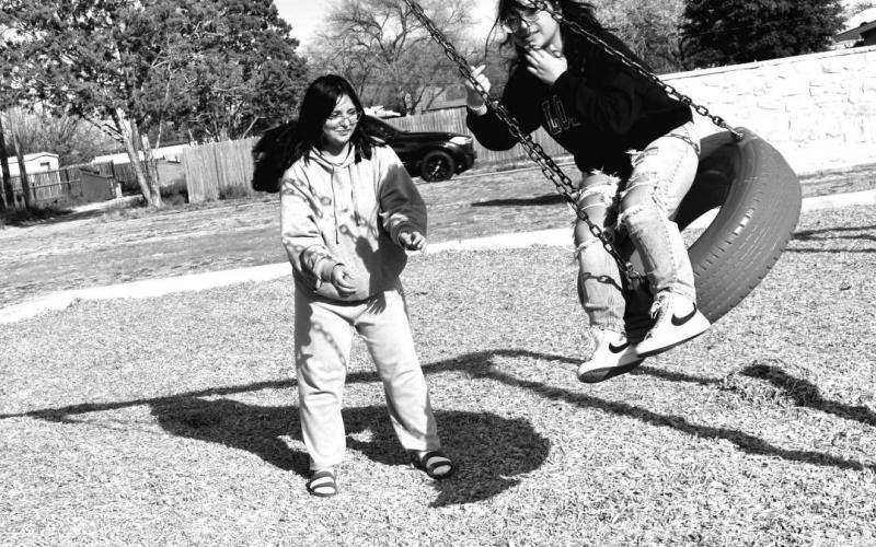 TIRE SWING FUN- At Bartlett Park on Tuesday afternoon In photo are Olivia Hinojosh and sister Anna Hinojosh had fun at the park enjoying being out of school for spring break and enjoying all the equipment at the Bartlett Park.( Staff photo by Emily Campos)
