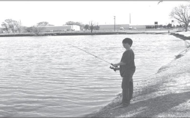 FISHING WEATHER- Ten year old Timothy Matthews ten yeras old in photo at Lobo Lake on Tuesday enjoying his spring break. Timothy said he hadn’t caught any fish but he said he had just starteded fishing and he was enjoying his Break from school. (Staff photo by Emily Campos)