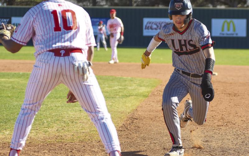 FULL SPEED - Levelland Lobo Rance Massey went at a full sprint to the first base after trying to steal a base in their matchup against the Perryton Rangers this past Friday at home. (Staff photo by Dom Puente)