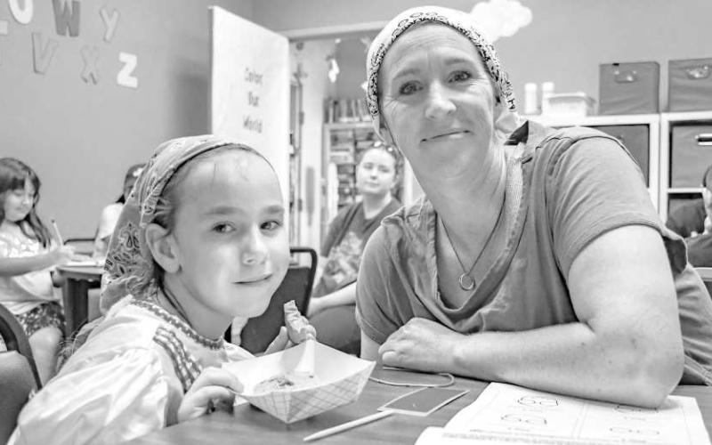 BOOKS AND BAGELS – Pictured is Willow Verner and Melanie Anderson at the Books and Bagels event held at the Hockley County Memorial Library on Wednesday. Kids and parents were able to color in coloring books made by the library and enjoy a bagel. (Staff photo by Ada Niederhauser)