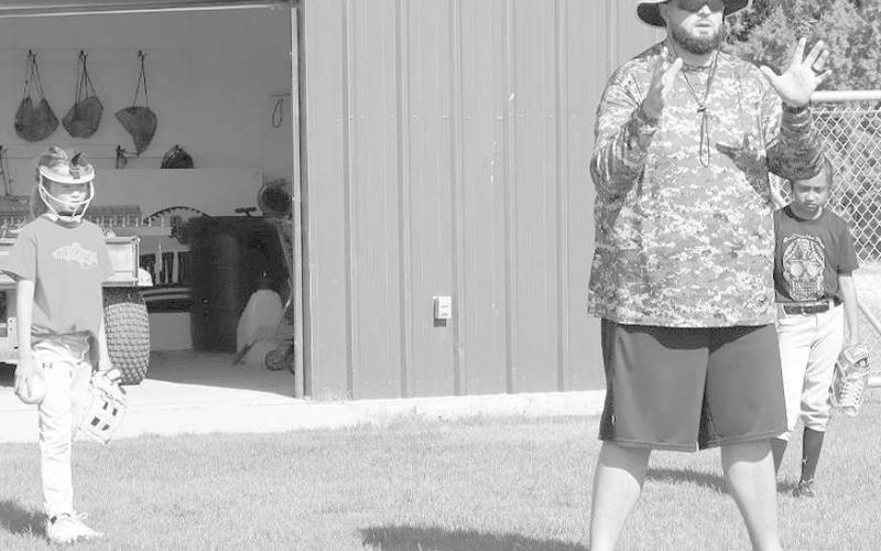 READY STANCE- Coach Ryan Miller shows the kids at the camp what their stance should be when throwing the ball the right way. The Loboette Softball Camp kicked-off Monday morning at Levelland High School. (Staff Photo by Aalijah Soliz)