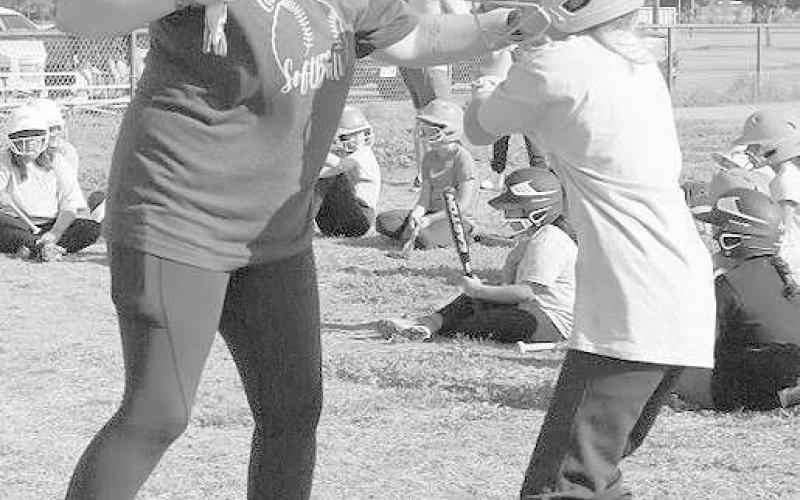 FUNDAMENTALS - Megan Villarreal was teaching Paige Montgomery the correct way to swing the bat during the summer youth softball league camp June 24. Batting was one of the highlighted topics of the camp. (Staff Photo by Aalijah Soliz)