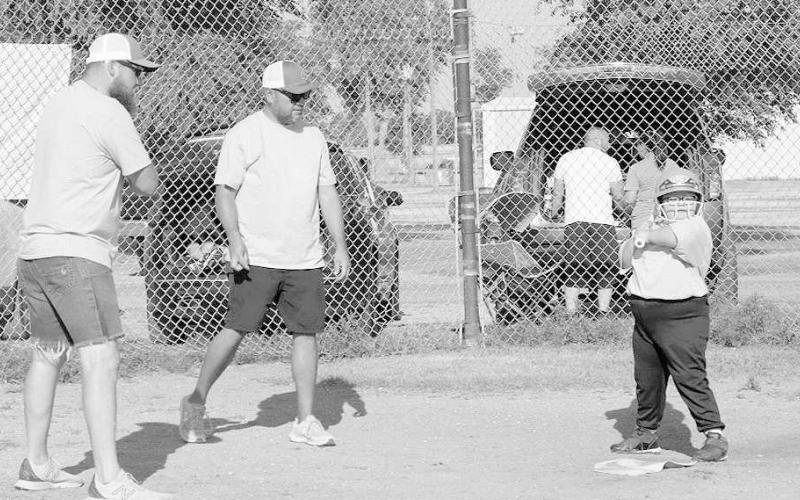 GOOD STANCE- Jacob Tucker and David Olivo gave batting stance lessons to Serenity Butler and the entire camp that was held June 23-24. The two-day camp covered all fundamentals associated with the game of softball such as fielding, throwing and hitting. This is the second year the youth softball league has held a summer camp with more participation each year. (Staff Photo by Aalijah Soliz)