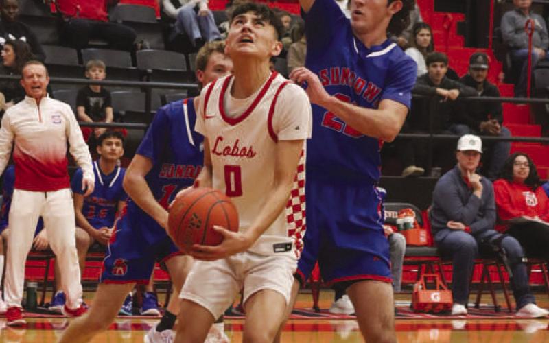 FOCUSED - Levelland Lobo Anthony Gonzalez was guarded closely by Sundown Roughneck Nathan McAdams under the basket during the team’s game last Friday night. (Staff photo by Aalijah Soliz)