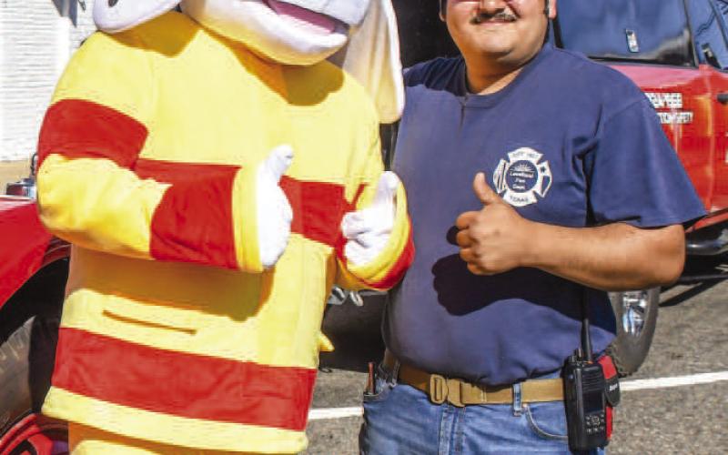 SPARKY PHOTOS – Sparky the Fire Dog and Jason waited to take photos with eventgoers beside a fire vehicle at downtown Levelland’s Falling for the Wallace festival on Saturday. The mascot was present for Levelland Fire Department’s Fire Prevention Day to let eventgoers know about smoke alarms. (Staff photo by Evin Thomas)