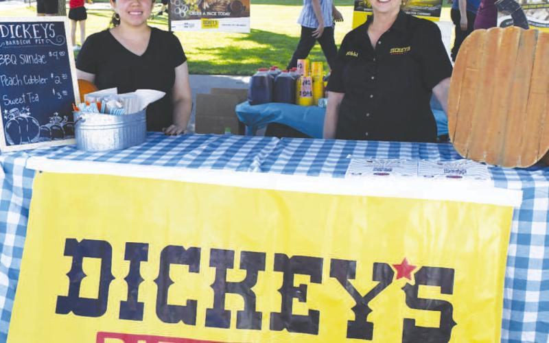 BARBECUE FOR SALE – Dickey’s Barbecue Pit staff smiled at their tent at Saturday’s Falling for the Wallace festival in downtown Levelland. The barbecue vendor was set up in front of the Hockley County Courthouse alongside food trucks parked on Avenue G.. (Staff photo by Evin Thomas)