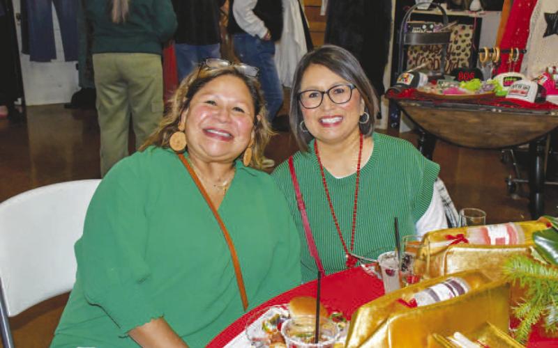MATCHING – Chris Paredez and Veronica Lopez smiled together at their reserved Fa La La table near the vendor stands in Levelland at the Mallet Event Center and Arena, Dec. 12. (Staff photo by Evin Thomas)