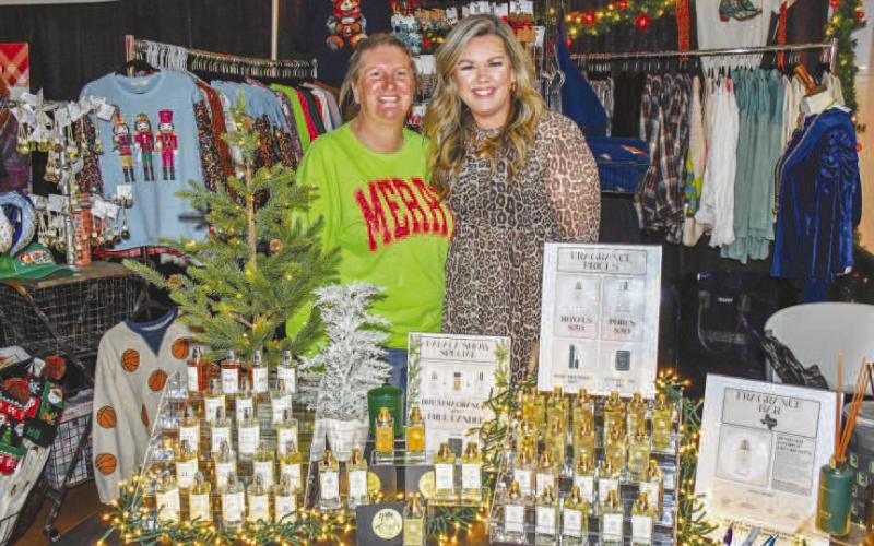 BRIGHT DISPLAYS – Amy Grissom and Paige Cunningham smiled at the Paisley Pearl Boutique vendor stand, which featured perfumes and other accessories for shoppers at Levelland’s Fa La La event Dec. 12. (Staff photo by Evin Thomas)