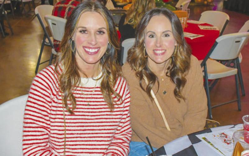 CHIT-CHAT – Kristie Moore and Misty Johnson sat and chatted at a decorated Fa La La event table amidst the shopping and music in Levelland, Dec. 12. (Staff photo by Evin Thomas)
